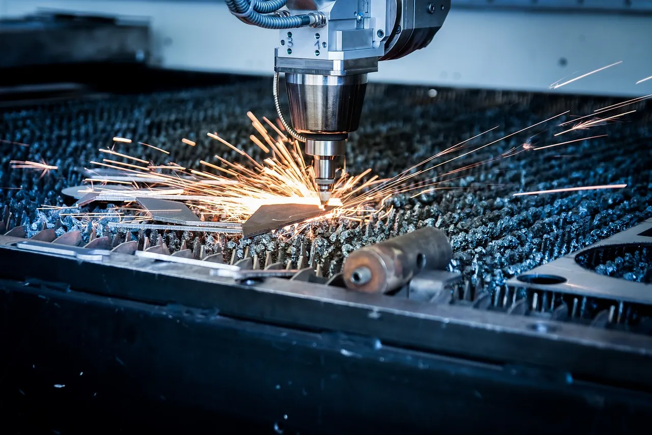 Fiber laser cutting head throwing sparks while cutting a steel sheet